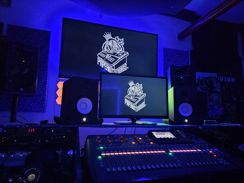 Paperkutz Studios control room with mixing console and branded screens